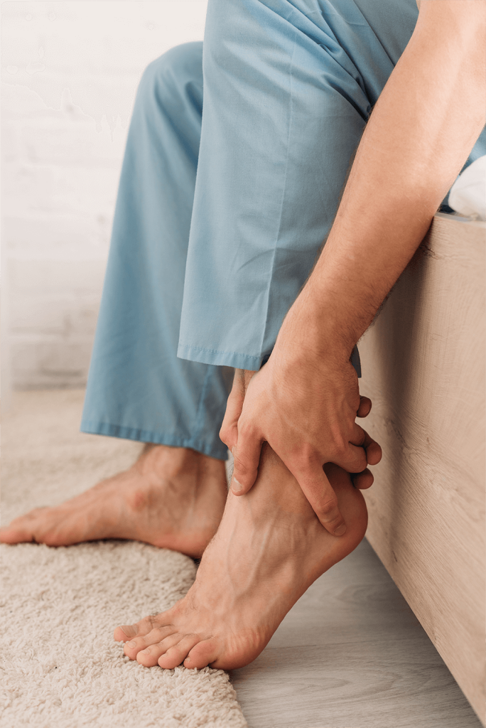 Man wearing pajama and touching leg while suffering from pain in Achilles tendon