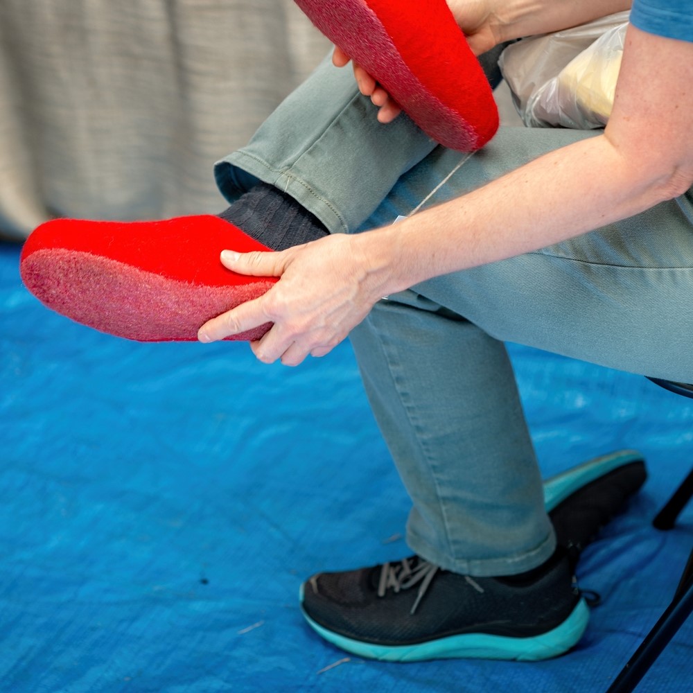 The man in the market measures red felt slippers. orthotics concept