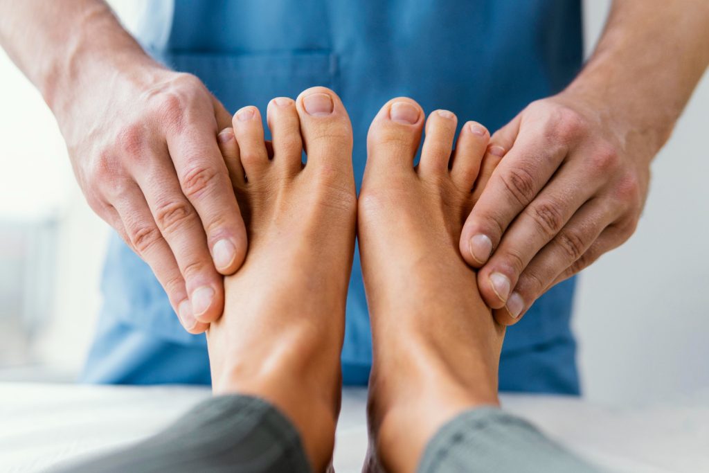 Front view of male osteopathic therapist checking female patient's toes. Regular foot check-ups concept.