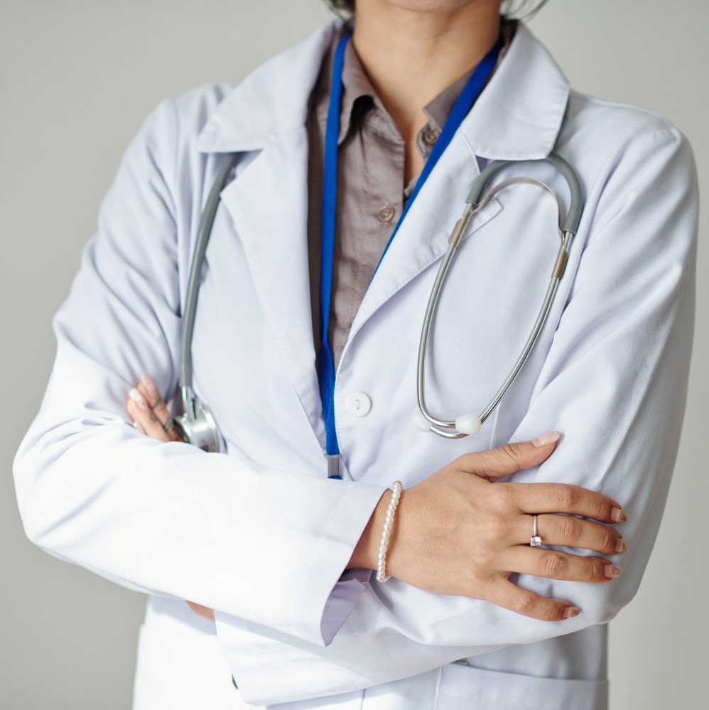 Cropped image of confident general practitioner in white lab coat crossing arms