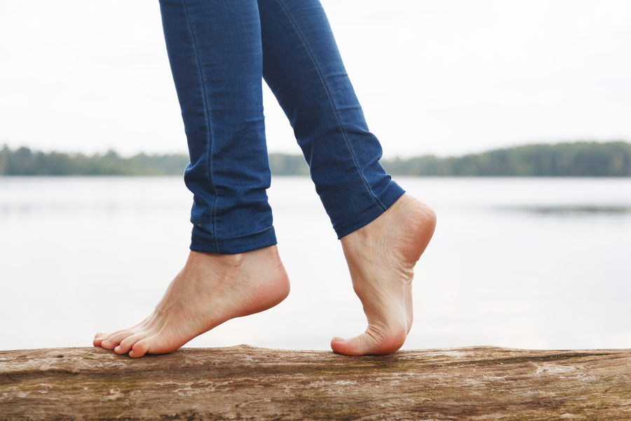 Woman’s feet walking on a log. Healthy feet concept.
