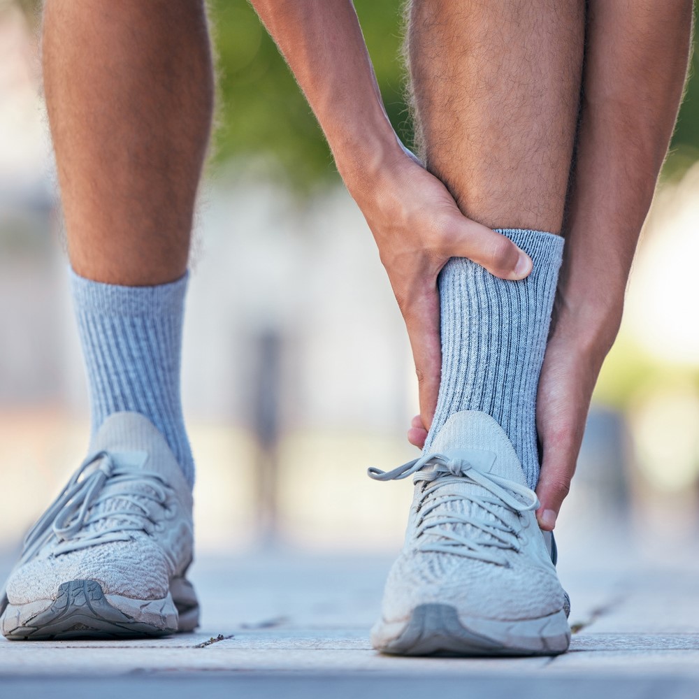 Man, feet or ankle pain in running fitness, training or exercise in New York city, street or road. Foot pain is serious, serious foot pain.
